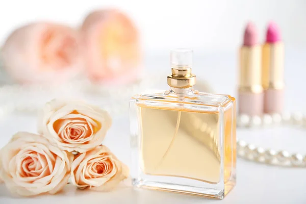 Perfume bottle with roses on white background