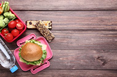 Sandviç ve sebze ahşap masa üzerinde okul öğle yemeği kutusu