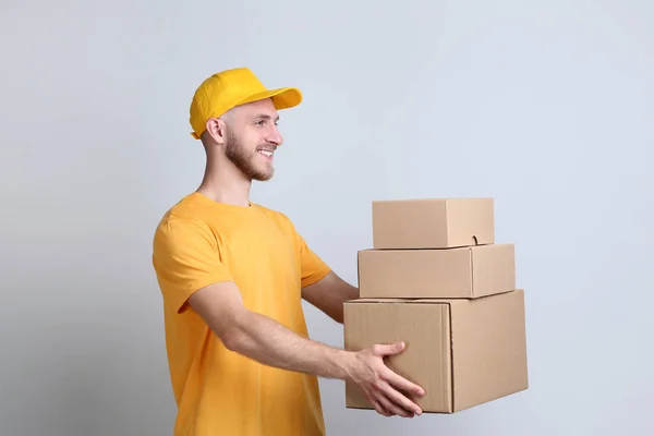 Delivery Man Holding Cardboard Boxes Grey Background — Stock Photo, Image