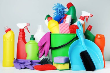 Şişe ile deterjan ve temizlik araçları gri arka plan üzerinde