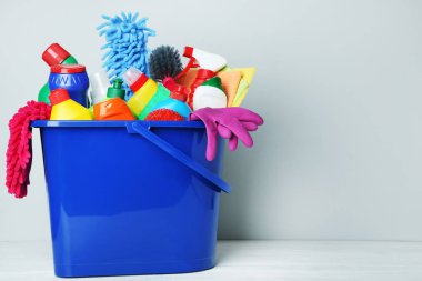 Şişe ile deterjan ve temizlik araçları gri arka plan üzerinde