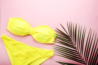 Yeşil palmiye yaprağı pembe bir arka plan üzerinde sarı mayo