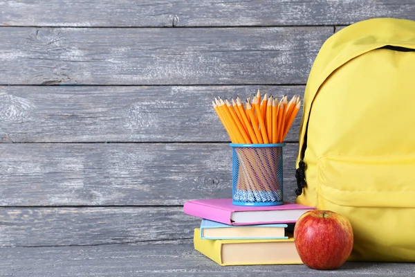 Mochila Amarilla Con Útiles Escolares Sobre Fondo Madera — Foto de Stock