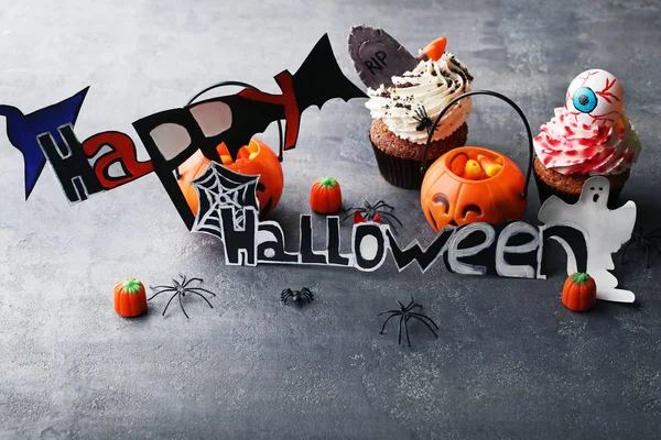 Şeker ve örümcekler gri ahşap masa ile Halloween cupcakes