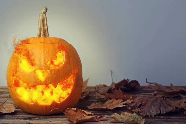 Halloween Pumpa Med Torra Löv Brunt Träbord — Stockfoto