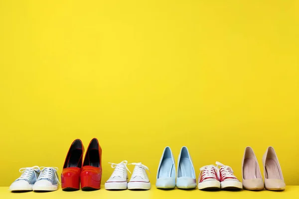 Zapatos Femeninos Diferentes Sobre Fondo Amarillo —  Fotos de Stock
