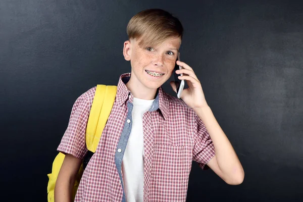 Kleiner Junge Mit Rucksack Und Smartphone Auf Tafel Hintergrund — Stockfoto