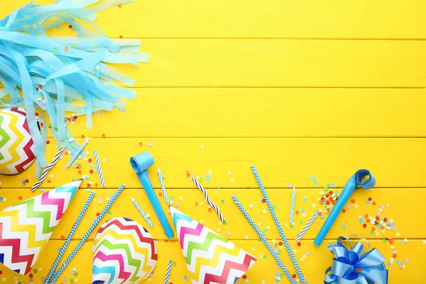 Gorras Papel Cumpleaños Con Velas Sopladores Sobre Mesa Madera Amarilla — Foto de Stock