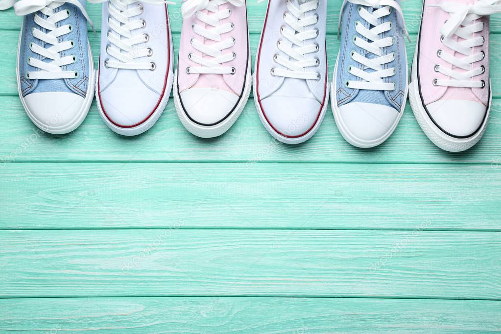 Different colorful sneakers on mint wooden table