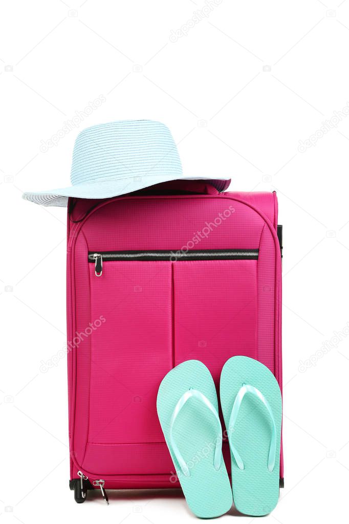 Pink suitcase with hat and flip flops isolated on white background