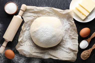 Yumurta ve ahşap masa üzerinde oklava ile çiğ hamur