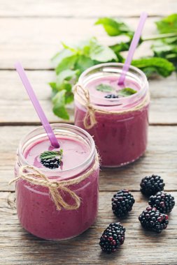 Böğürtlen yoğurt şişelerde gri ahşap tablo