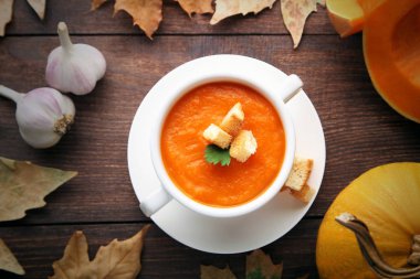 Peksimet ve plaka üzerinde ahşap masa maydanoz ile kabak çorbası