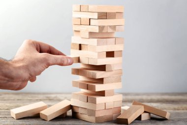 Erkek el oyun ahşap bloklar oyun gri arka plan üzerinde kule