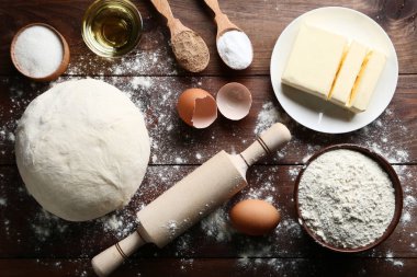 Tereyağı, yumurta ve ahşap masa üzerinde oklava ile çiğ hamur