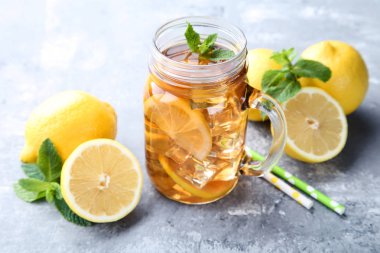 Buzlu çay limon ve nane ile cam kavanoza ahşap masaya yapraklar