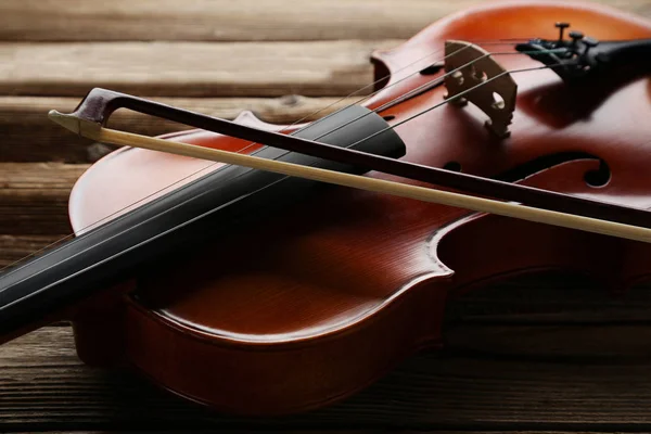 Violin with bow on brown wooden table