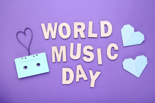 Cassette tape with inscription World Music Day on purple background