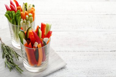 Ahşap masa üzerinde bardaklarda sebze dilimlenmiş