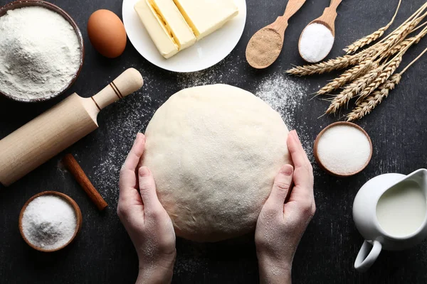 Manos Femeninas Sosteniendo Masa Cruda Con Mantequilla Leche Sobre Mesa —  Fotos de Stock