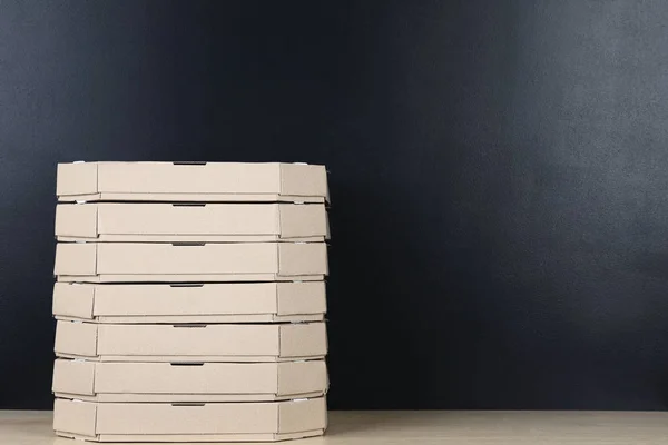 Stack of pizza boxes isolated on black background