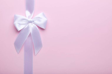 Yay ile şerit pembe bir arka plan üzerinde beyaz