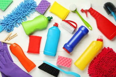 Şişe ile deterjan ve temizlik araçları Beyaz ahşap zemin üzerinde