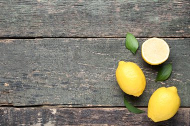 taze bütün ve yeşil ile yarıya limon yaprakları üzerinde gri ahşap masa