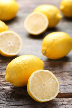 Kahverengi ahşap masa üzerinde olgunlaşmış bütün ve yarıya limon