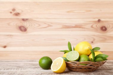 taze bütün ve yarıya limon ve limes yeşil yaprakları sepete ahşap tablo
