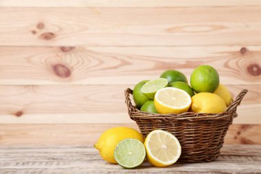 taze bütün ve yarıya olgun limon ve limes sepeti ahşap tablo