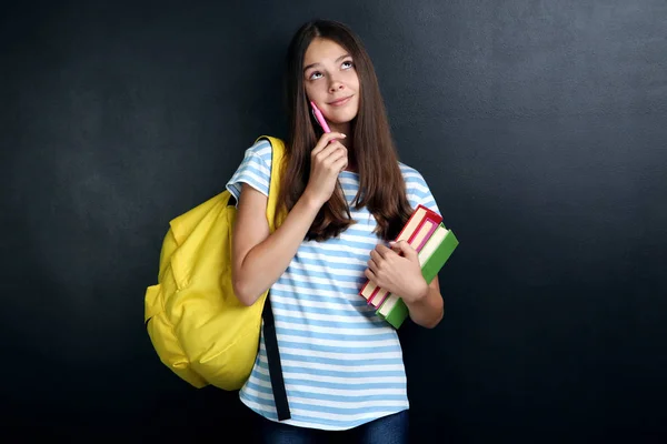 Junges Mädchen Mit Rucksack Und Büchern Auf Tafel Hintergrund — Stockfoto