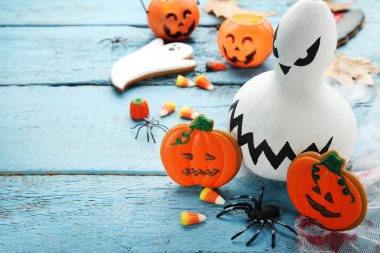 Cadılar Bayramı gingerbread çerezleri ve mavi ahşap masa üzerinde beyaz kabak