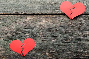 Gri ahşap arka plan üzerinde kırmızı kırık kalpler