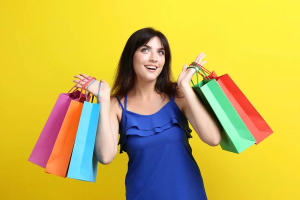 Junge Frau Mit Einkaufstaschen Auf Gelbem Hintergrund — Stockfoto