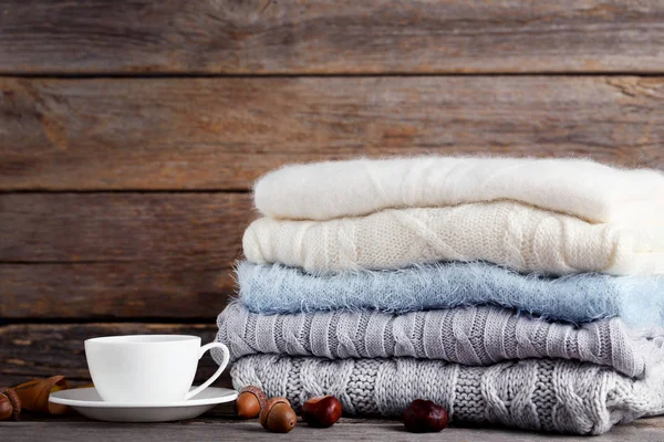 Stapel Gebreide Truien Met Kopje Thee Eikels Kastanjes Houten Achtergrond — Stockfoto