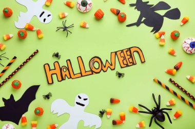 Şeker ve kağıt süsleme yeşil arka plan üzerinde yazıt Halloween