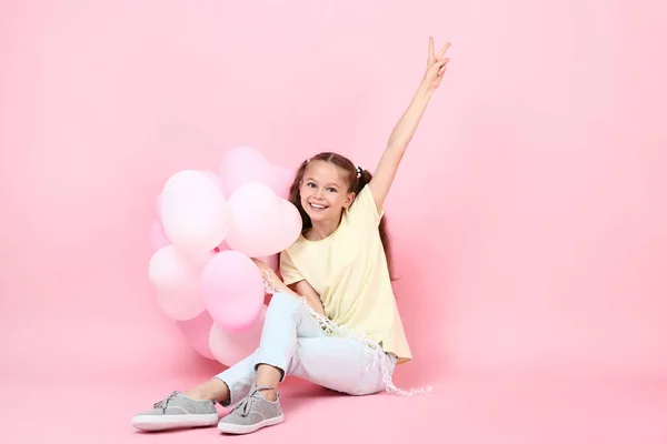 Schattig Jong Meisje Met Ballonnen Zittend Roze Achtergrond — Stockfoto