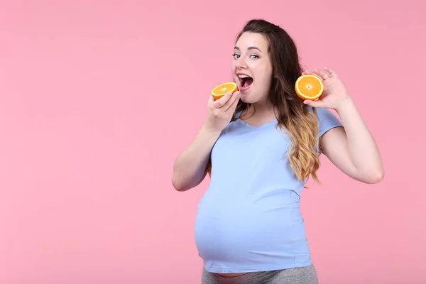 Piękna Kobieta Ciąży Pomarańczowy Owoc Różowym Tle — Zdjęcie stockowe