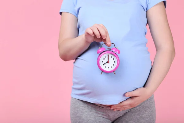 Zwangere Vrouw Met Wekker Roze Achtergrond — Stockfoto