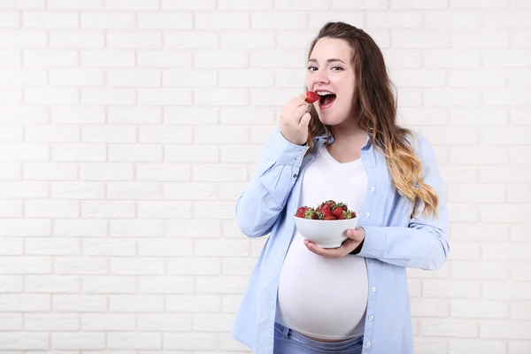 Mooie Zwangere Vrouw Met Aardbeien Kom Bakstenen Muur Achtergrond — Stockfoto