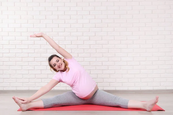 Mladá Těhotná Žena Dělá Cvičení Cihlovou Zeď Pozadí — Stock fotografie