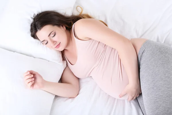 ベッドで寝ている若い妊婦は — ストック写真