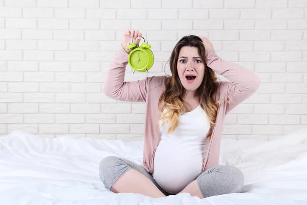 Mooie Zwangere Vrouw Met Wekker Zittend Bed — Stockfoto