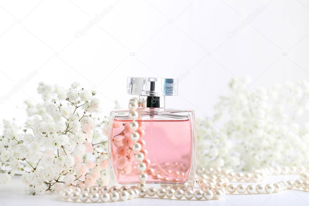 Perfume bottle with eustoma flowers on white background