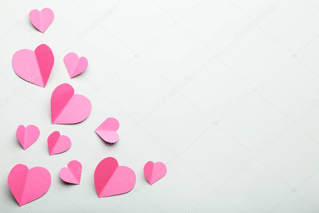 Pink paper hearts on grey background