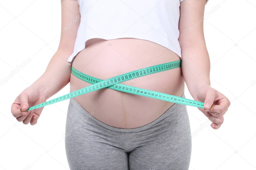 Pregnant woman with measuring tape on white background