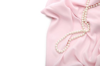 Beyaz arka plan üzerinde pembe saten kumaş ile inci kolye