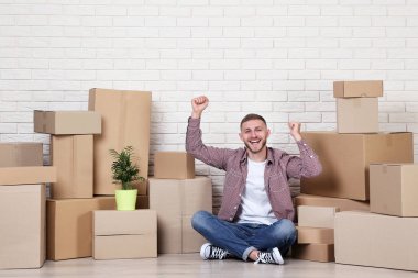 Tuğla duvar zemin üzerine karton kutular ile genç adam