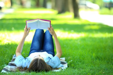 Sevimli kız parkta kitapla yalan